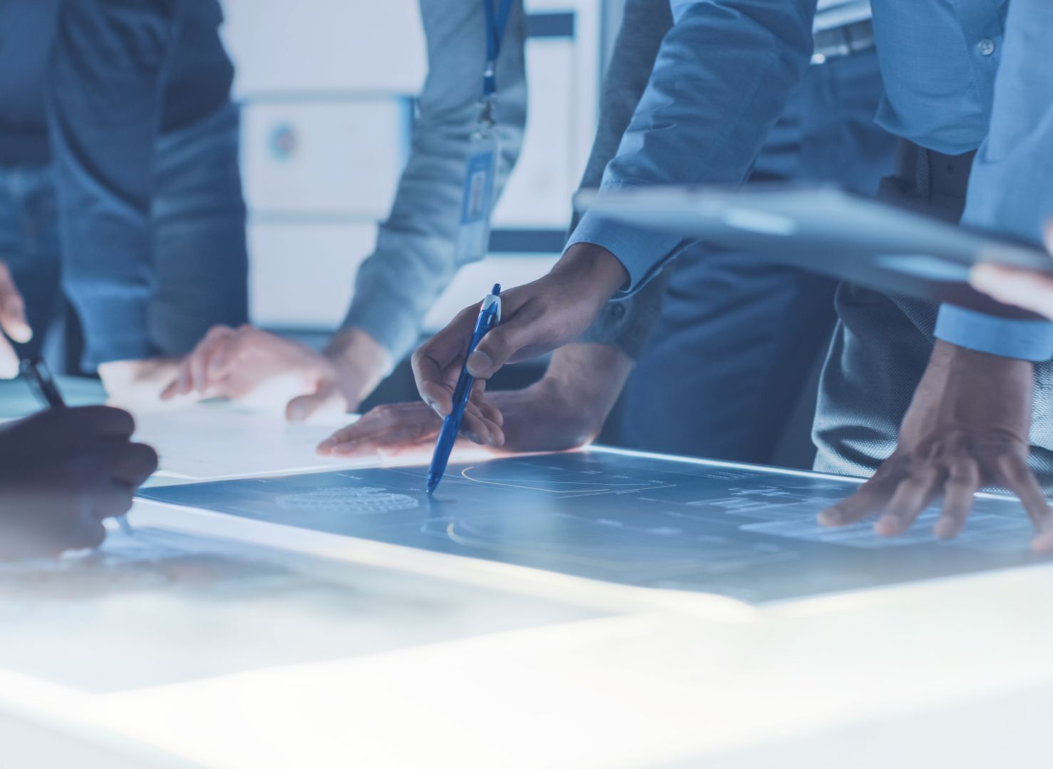 Michael Kamp Auditierung Männer um Plan und Tisch herum stehend