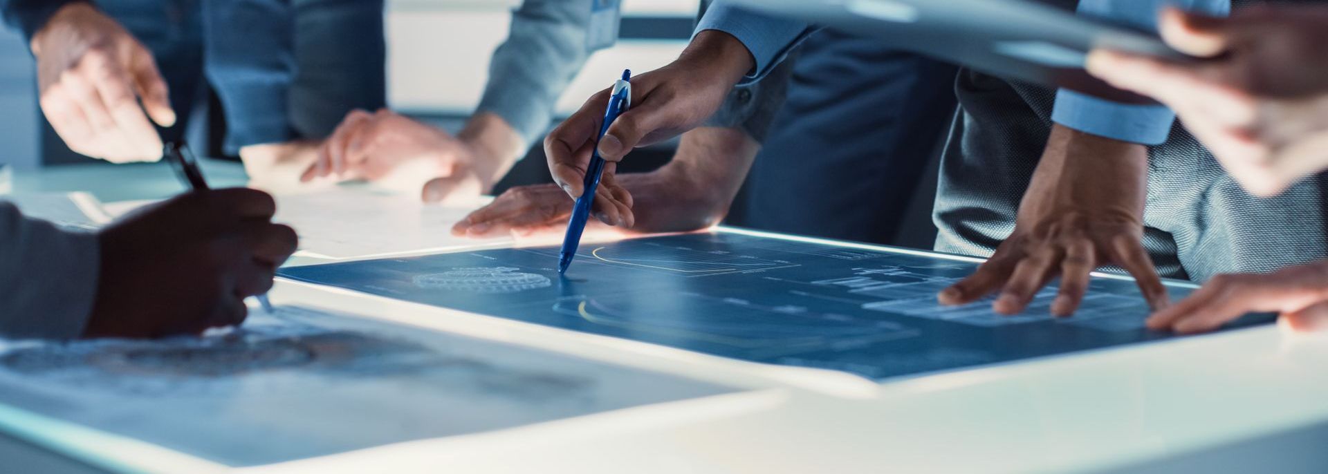 Managementsysteme Michael Kamp Hände zeigen auf Karte mit Stift