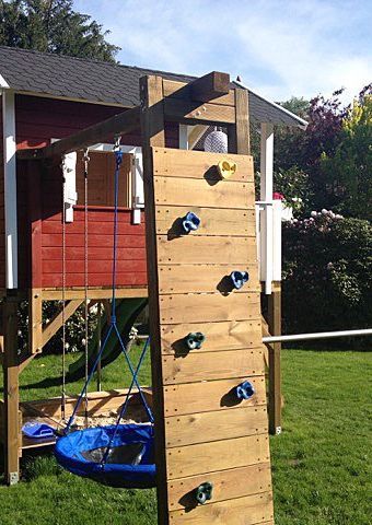 Stelzenhaus von Kaso aus Mücke mit Kletterwand aus Holz und bunten Sprossen, Wellenrutsche und Schaukel