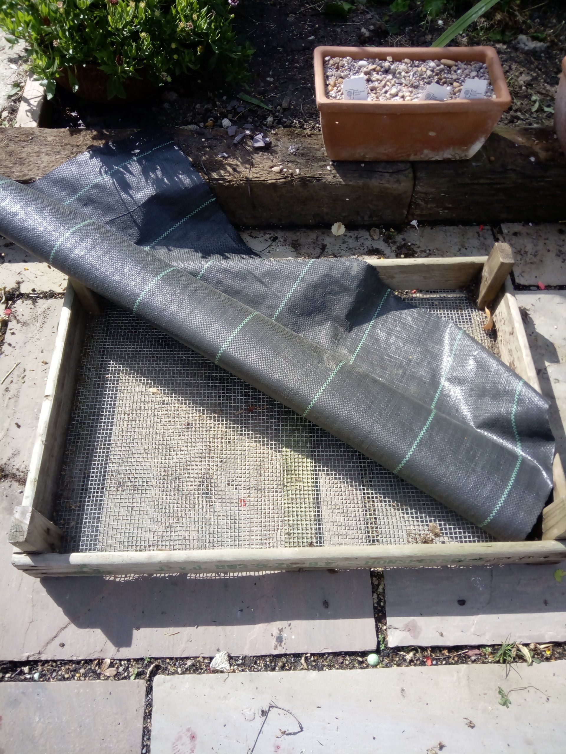 Line the crate with weed control fabric