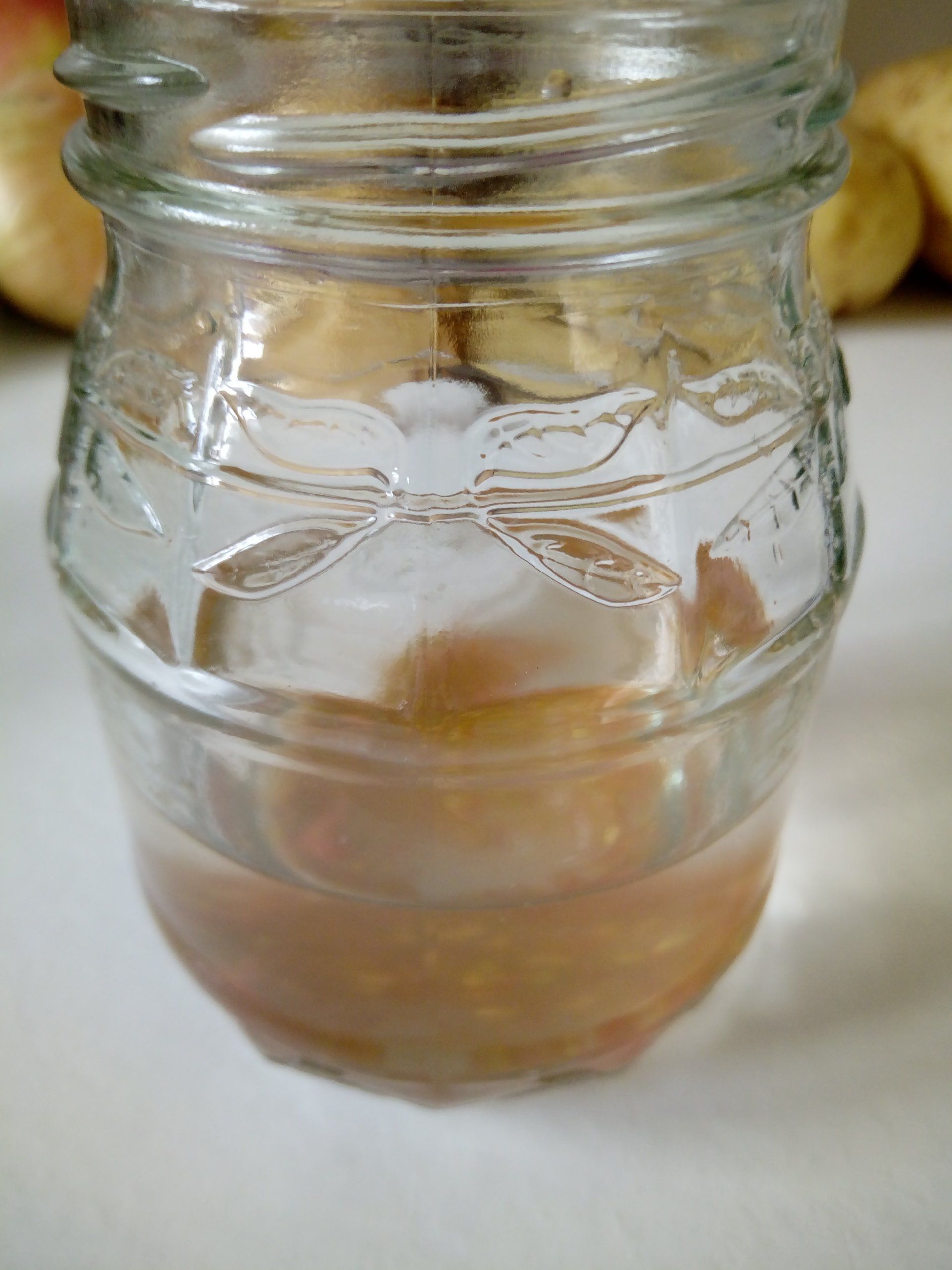 Tomato Seeds Fermenting in the Water in the Bottom of  a Jam Jar