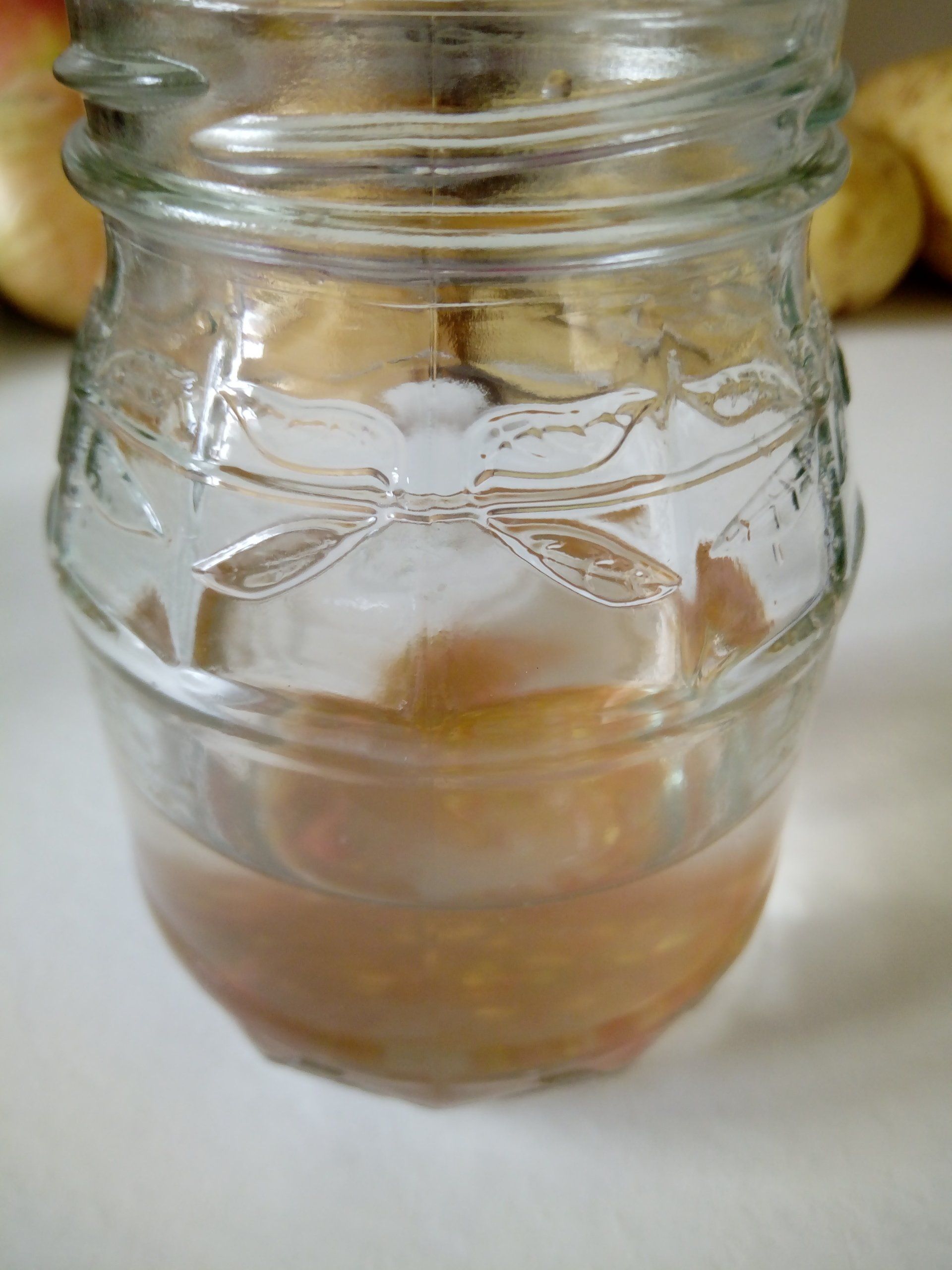 Tomato Seeds Fermenting in the Water in the Bottom of a Jam Jar