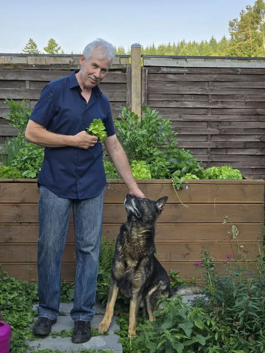 Dirk Schwartz mit Deutschem Schäferhund im Garten vorm Kräuter-Hochbeet in Pfaffenheck