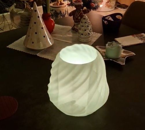 Leuchtendes 3-D-gedrucktes Windlicht in weiß, Weihnachtsdeko im Hintergrund