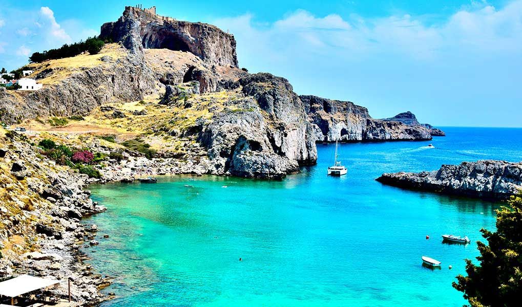 Lindos Acropolis overlooking a turquoise bay on Rhodes, Greece.