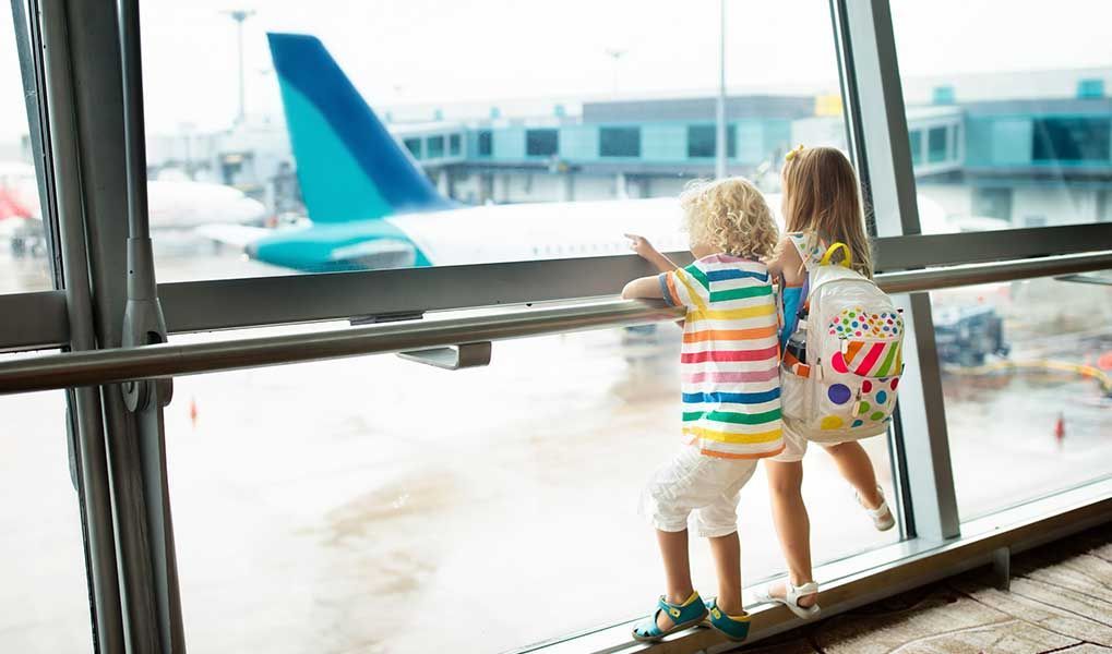 Children watching aircraft at the airport before their family holiday. Children watching aircraft at the airport before their family holiday.