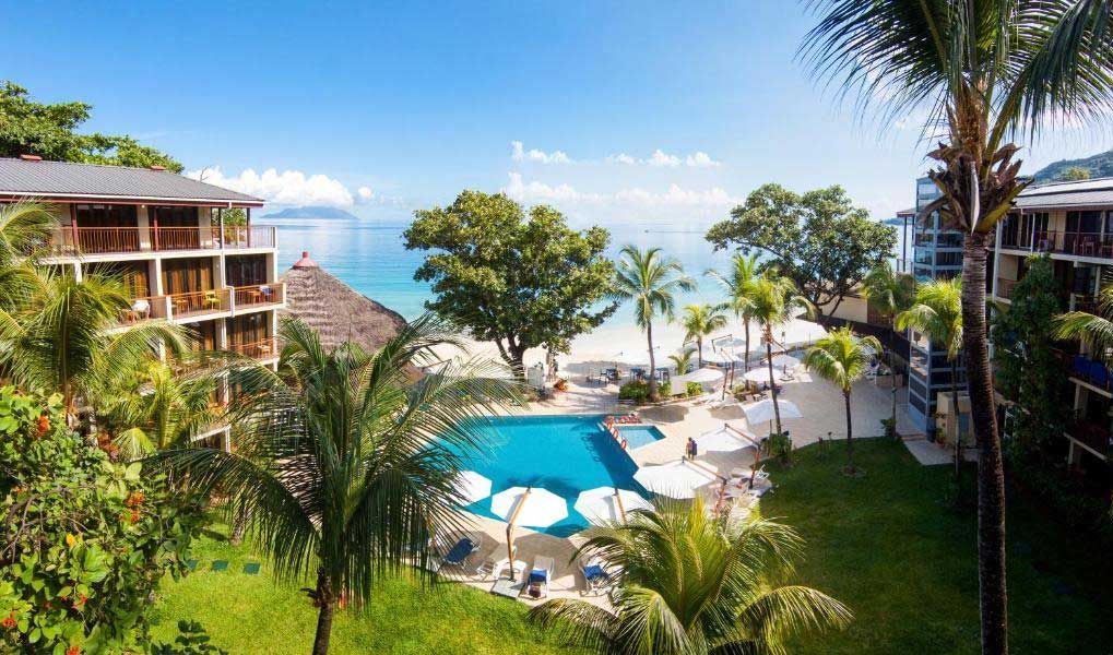 Tropical Seychelles resort with pool, palm trees and direct beach access. Tropical Seychelles resort with pool, palm trees and direct beach access.