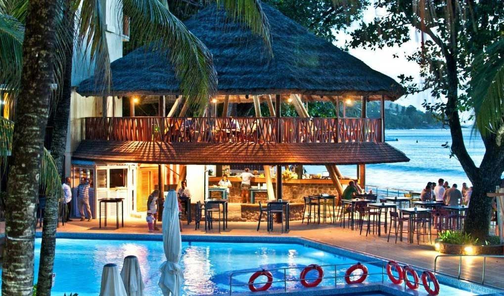 Poolside bar at a beachfront Seychelles resort surrounded by palm trees. Poolside bar at a beachfront Seychelles resort surrounded by palm trees.