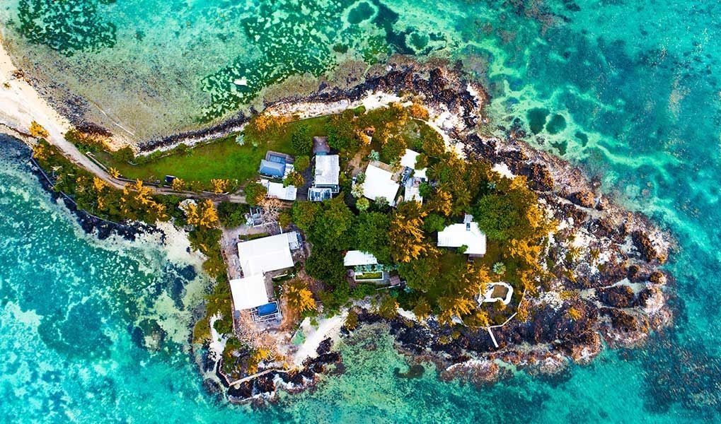 Aerial view of a private island resort surrounded by Mauritius’ turquoise lagoon.