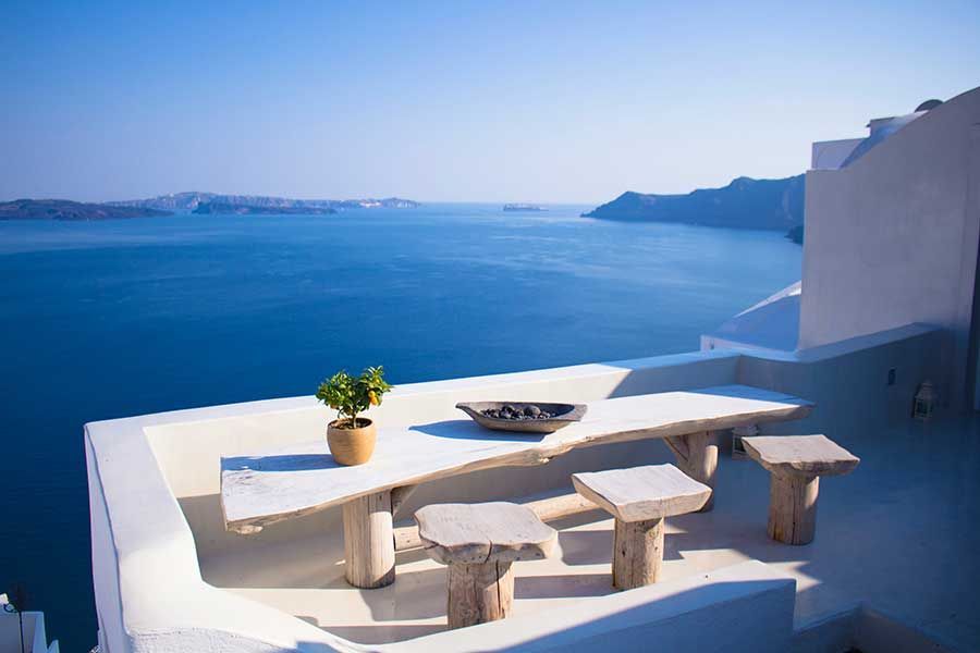 Wooden terrace overlooking Santorini's caldera and the sea, white buildings nearby