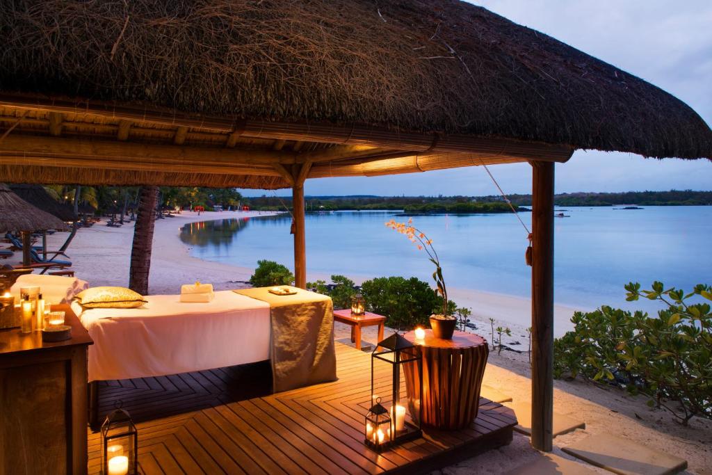 Outdoor beach spa gazebo with massage table and candles overlooking the ocean Outdoor beach spa gazebo with massage table and candles overlooking the ocean