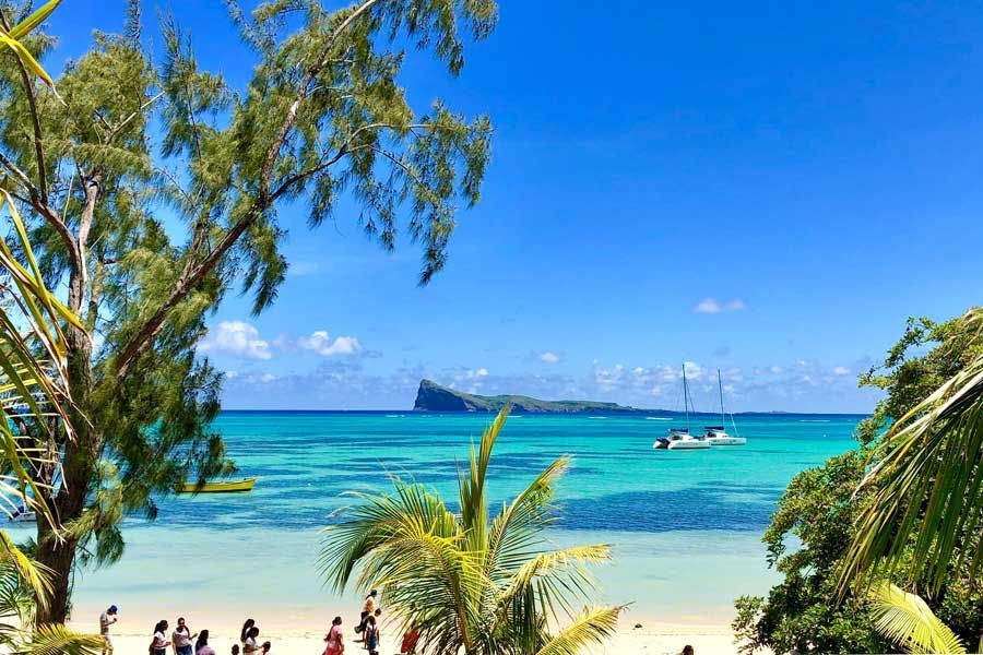 Turquoise lagoon and Coin de Mire views from a tropical beach in Mauritius.