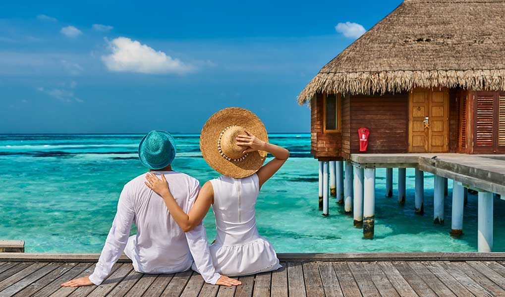 Couple relaxing beside an overwater villa in the Maldives. Couple relaxing beside an overwater villa in the Maldives.