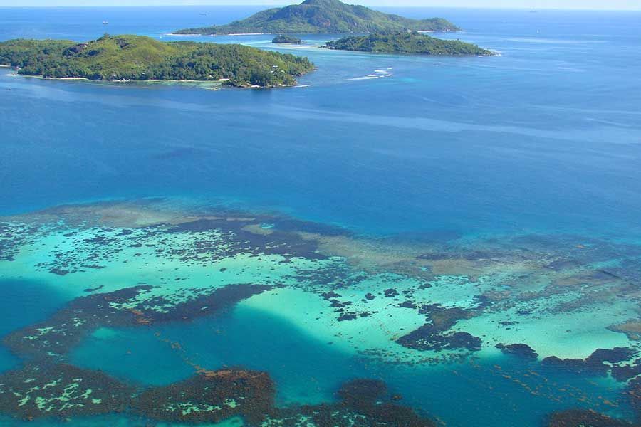 Aerial view of coral reefs and tropical islands in the Seychelles.