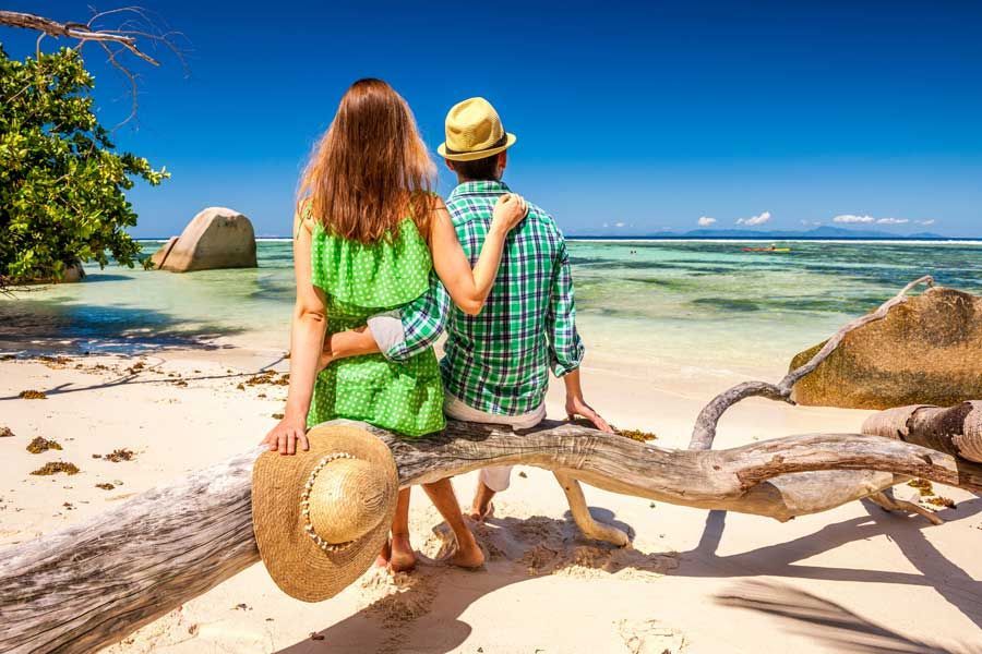 Couple enjoying a peaceful tropical beach in the Seychelles.