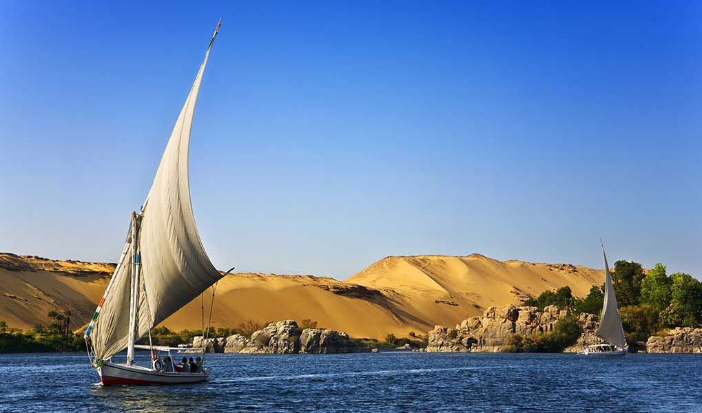 Traditional felucca sailing on the Nile River near Aswan, Egypt.