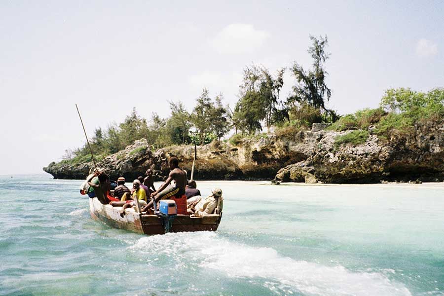 Boat trip through Zanzibar’s turquoise coastal waters and rocky island scenery.