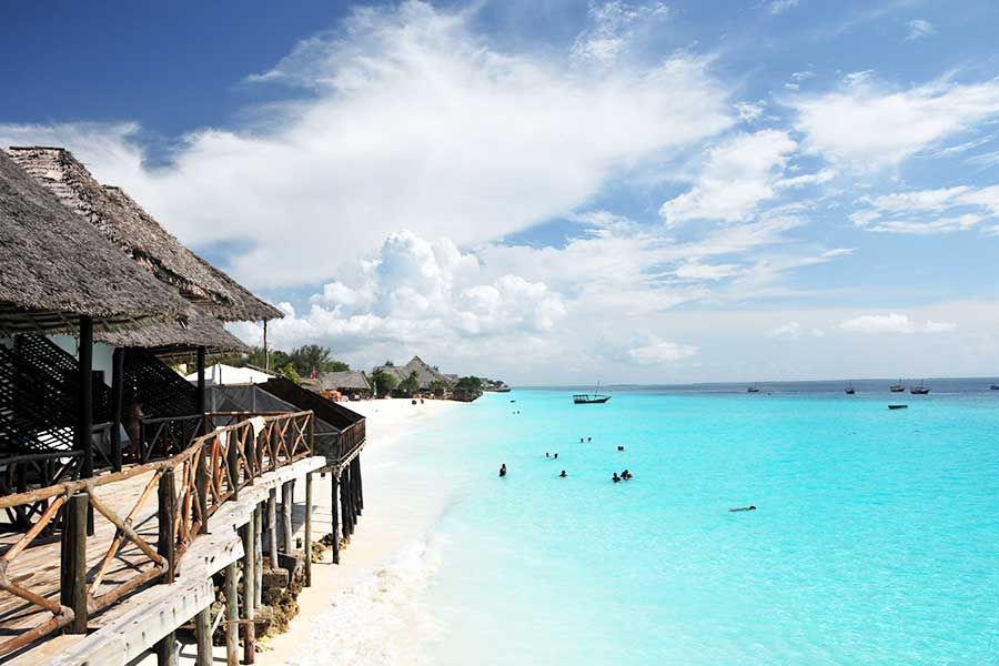 Zanzibar beach resort with white sand and crystal-clear turquoise water.