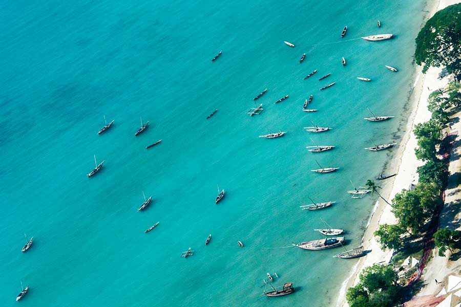 Aerial view of traditional boats along Zanzibar’s turquoise coastline. Aerial view of traditional boats along Zanzibar’s turquoise coastline.