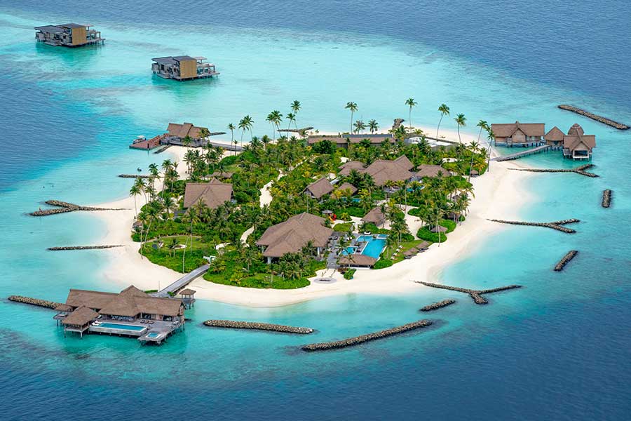 Aerial view of an overwater bungalow resort island in the Maldives, surrounded by turquoise lagoon Aerial view of an overwater bungalow resort island in the Maldives, surrounded by turquoise lagoon