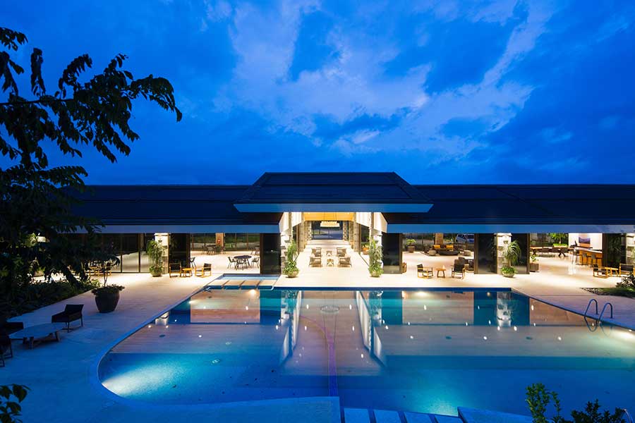 Tropical resort pool with sun loungers, palm trees, and mountain views Tropical resort pool with sun loungers, palm trees, and mountain views