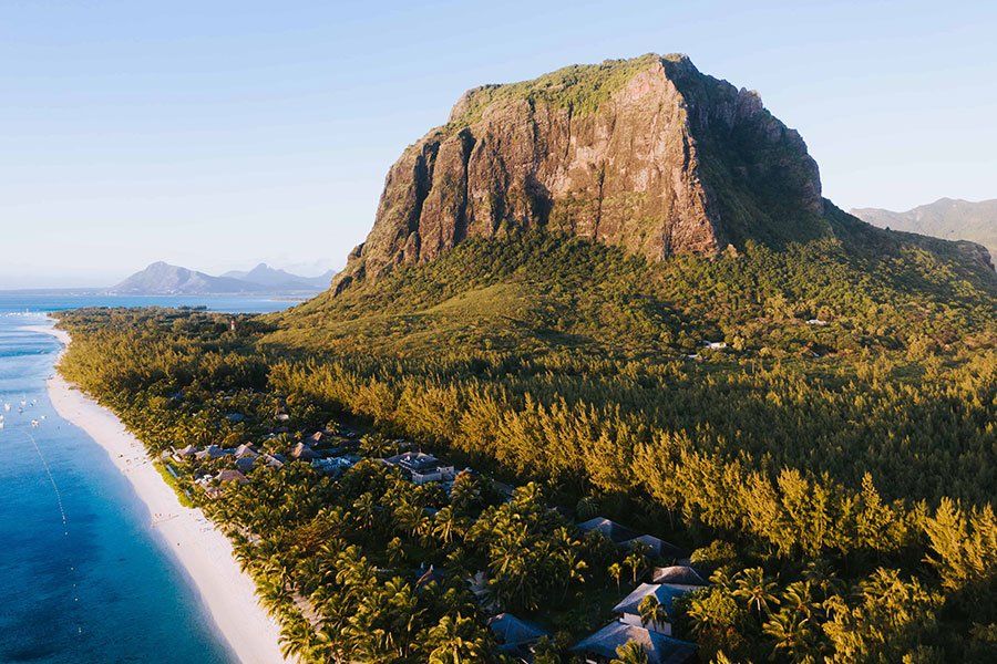 Aerial view of Le Morne Brabant mountain in Mauritius, with beachfront resorts along the sandy shoreline Aerial view of Le Morne Brabant mountain in Mauritius, with beachfront resorts along the sandy shoreline