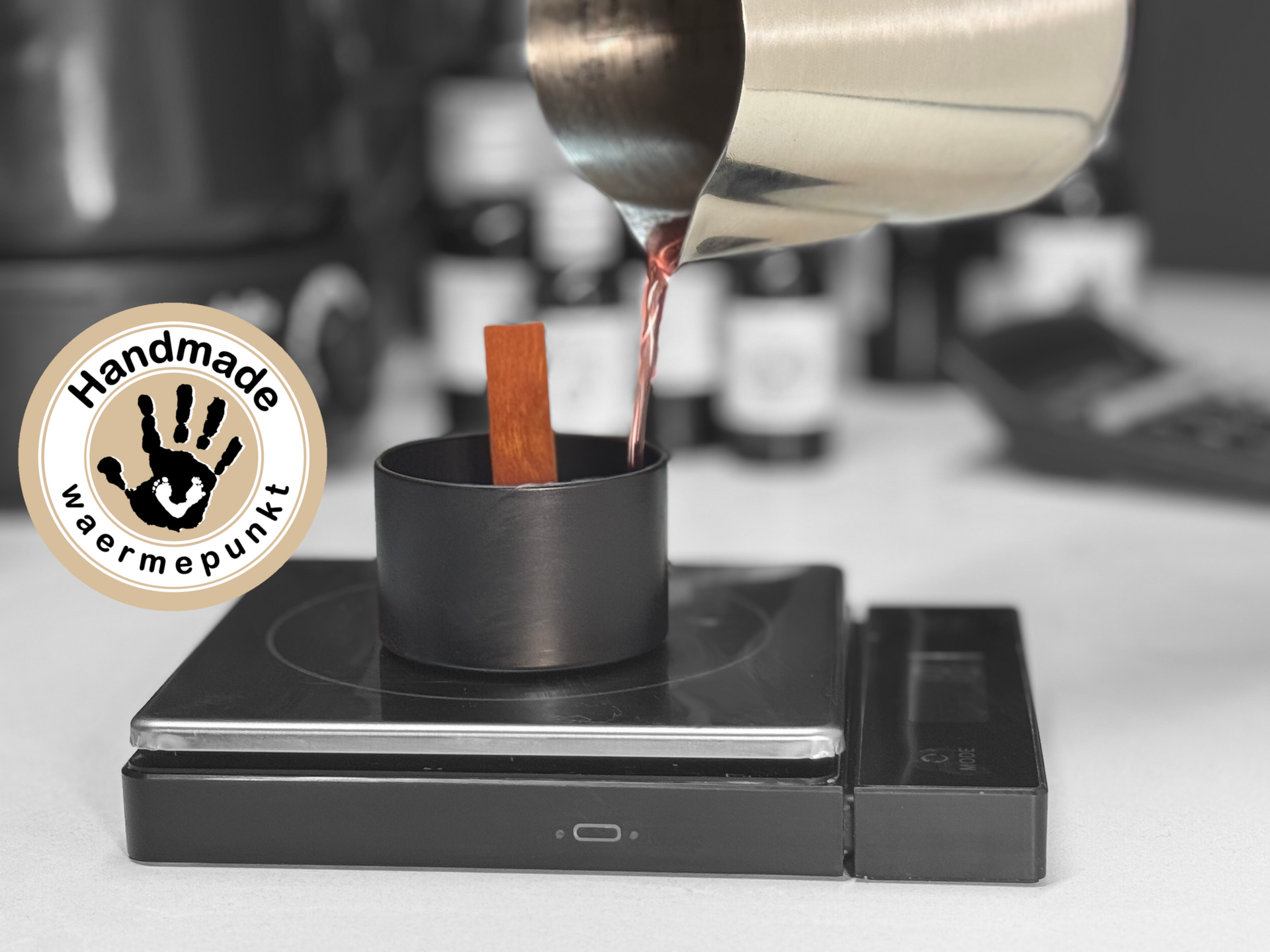 Eine Gießkanne mit Wachs, welche in rosa Farbe eine Kerze gießt und auf der linken Seite ein Button von Waermepunkt in der darauf verwiesen wird, dass es von Waermepunkt handgemachte Kerzen sind.