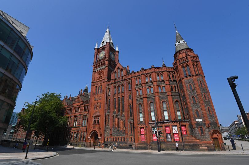 A picture of a building, sky, road and tree