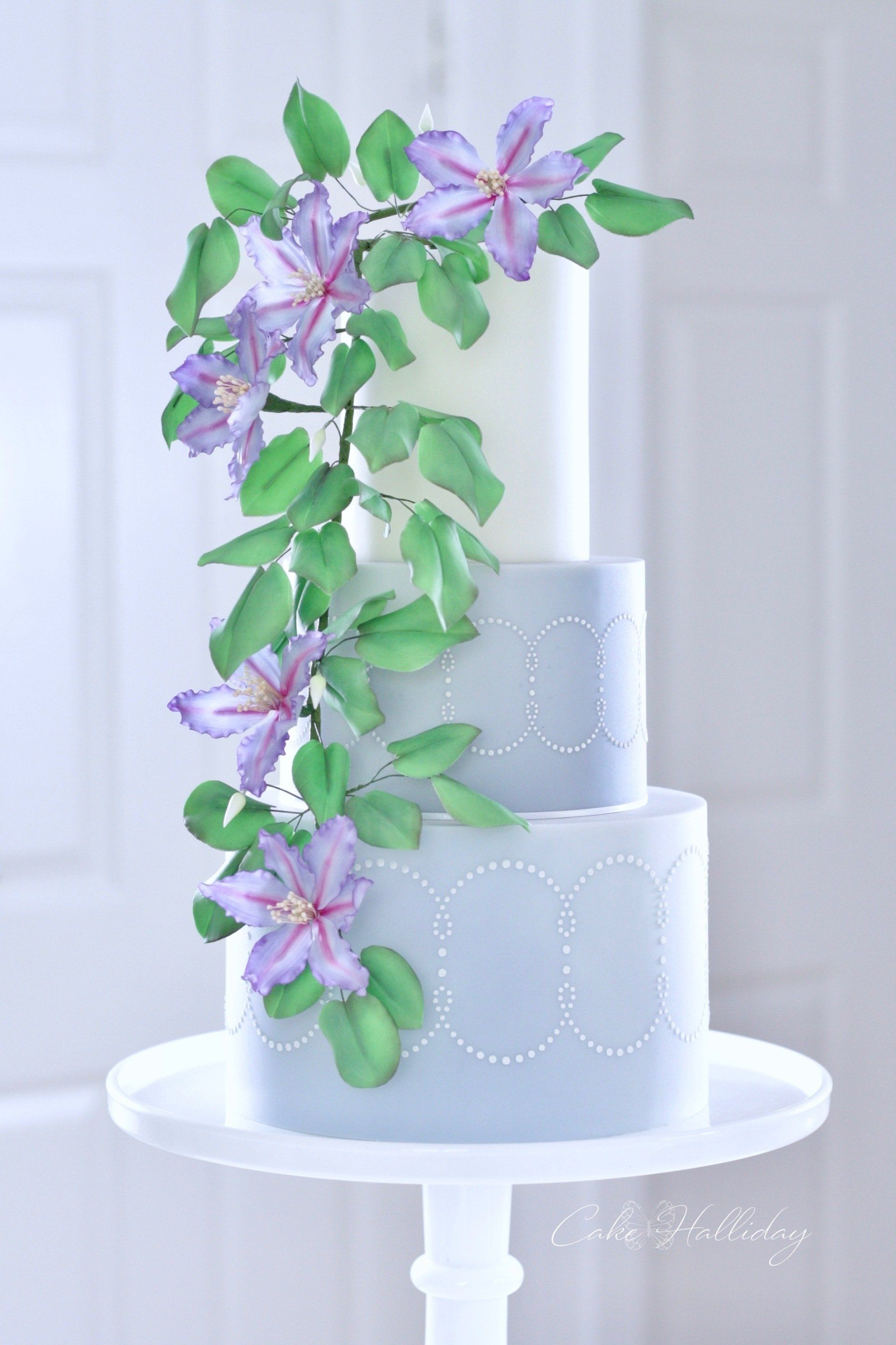 Three tier wedding cake with purple clematis and stencilling