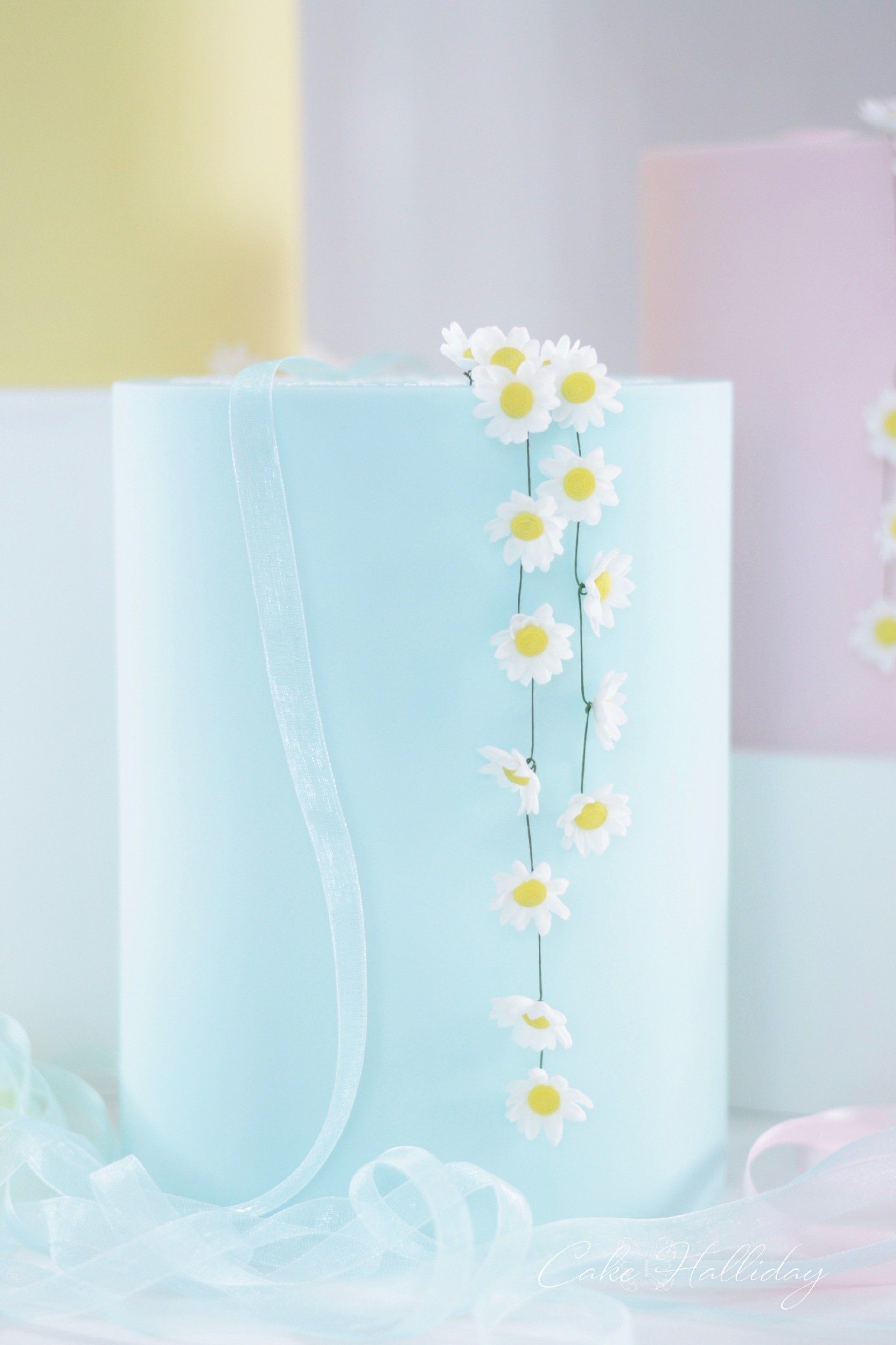 Blue single tier wedding cake with daisy chain