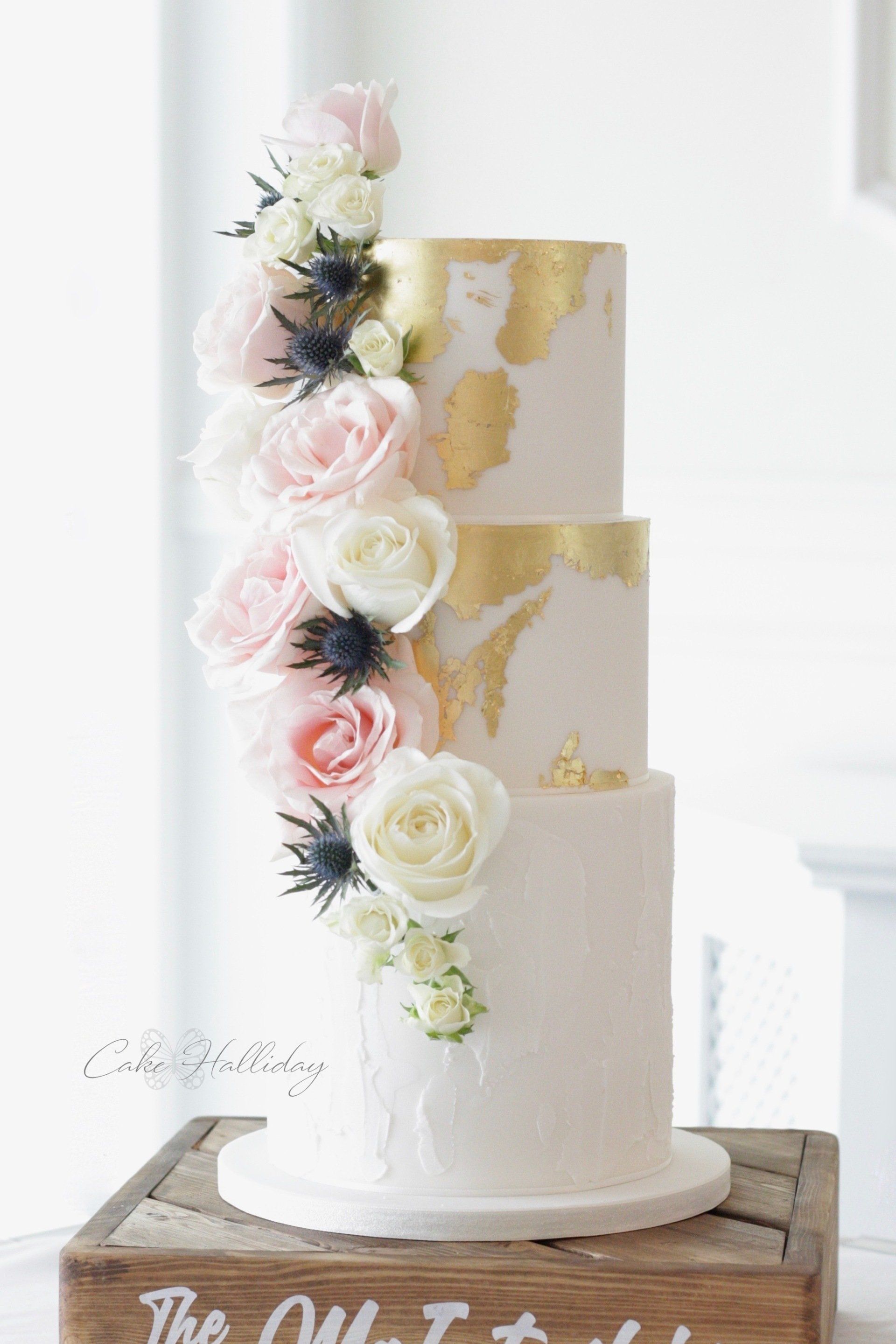 Gold leaf, roses & sea holly wedding cake