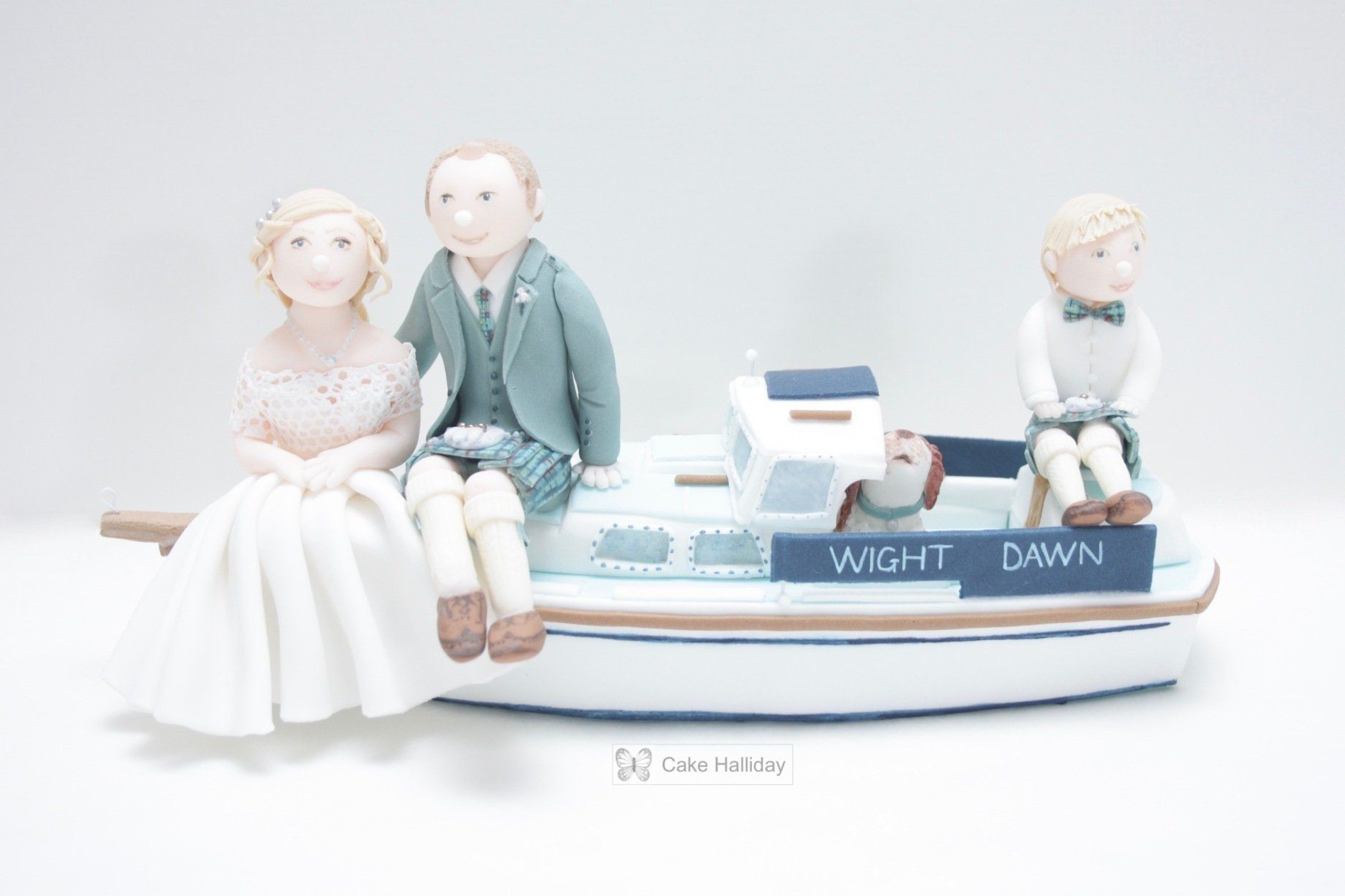 Wedding cake boat topper with sugar figures of bride, groom (in kilt), page boy & family pet. Ayrshire, Glasgow, Scotland.