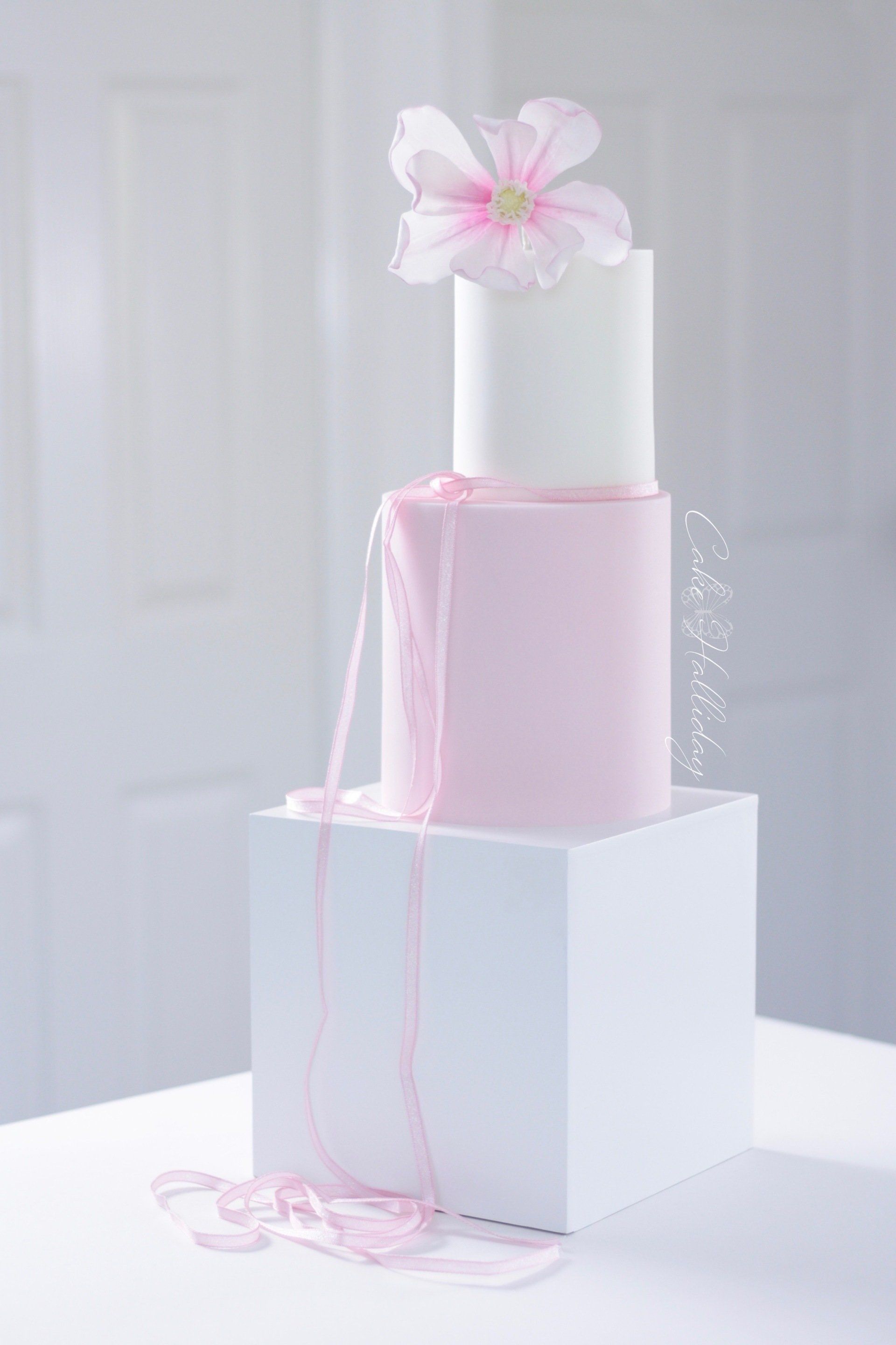 Pink and white wedding cake with sugar magnolia