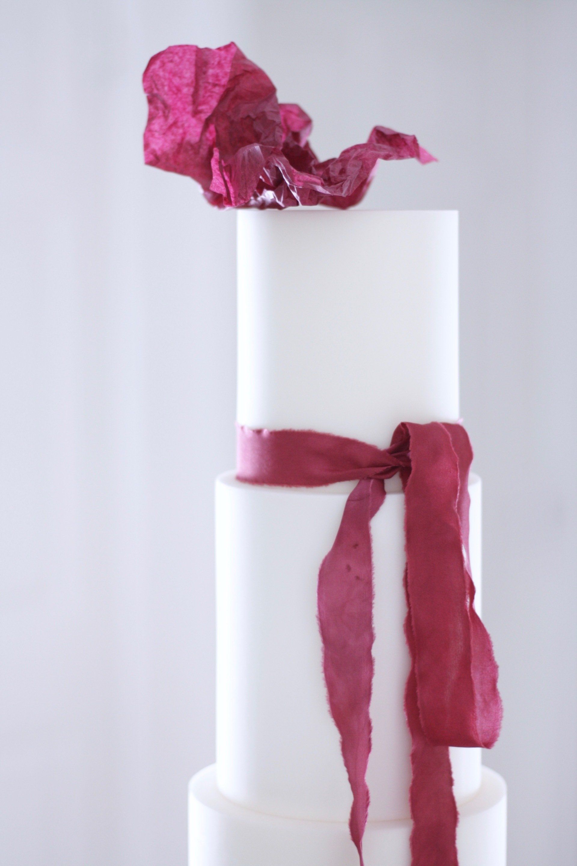 Minimalist wedding cake with burgundy silk ribbon