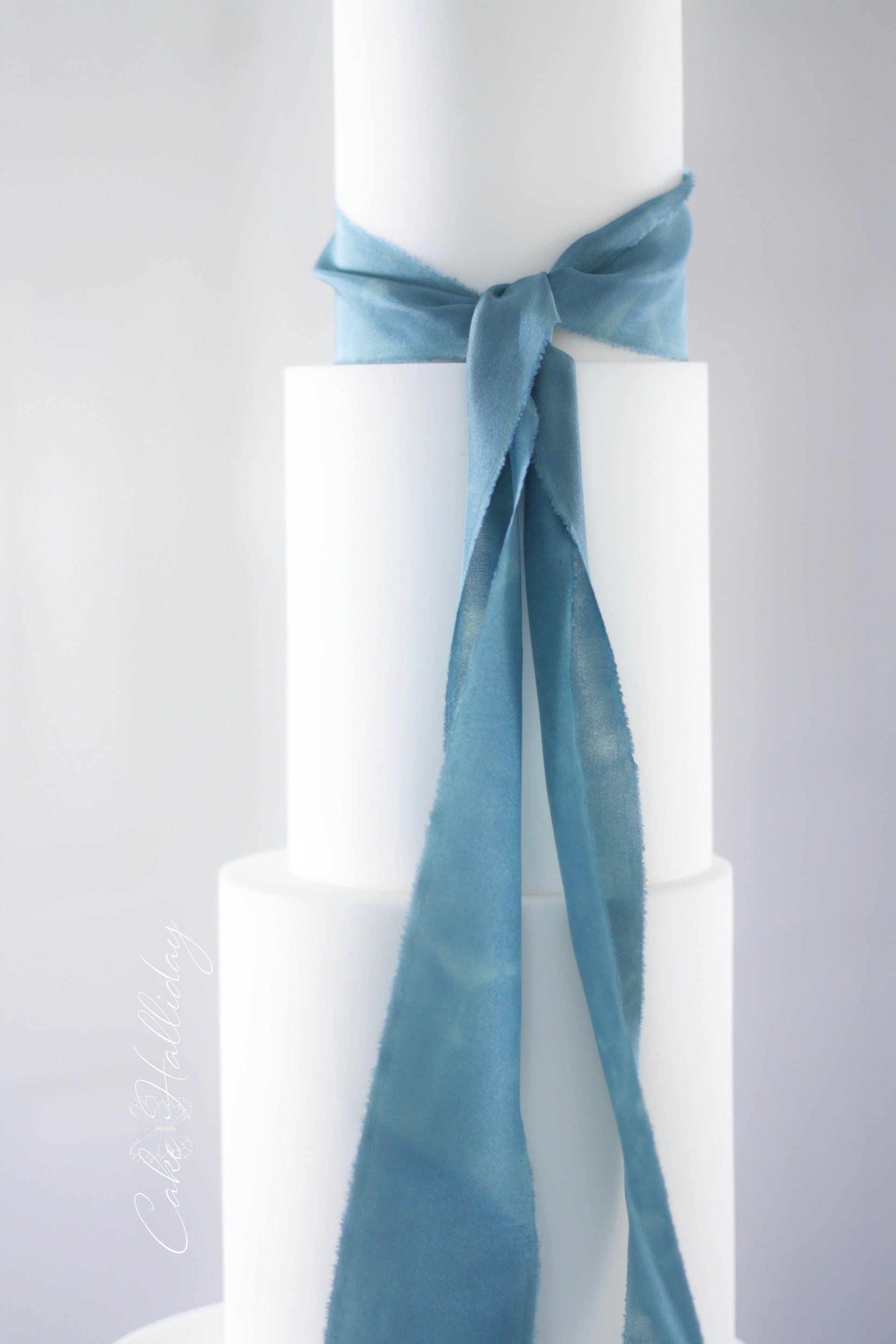 Minimalist wedding cake with teal silk ribbon