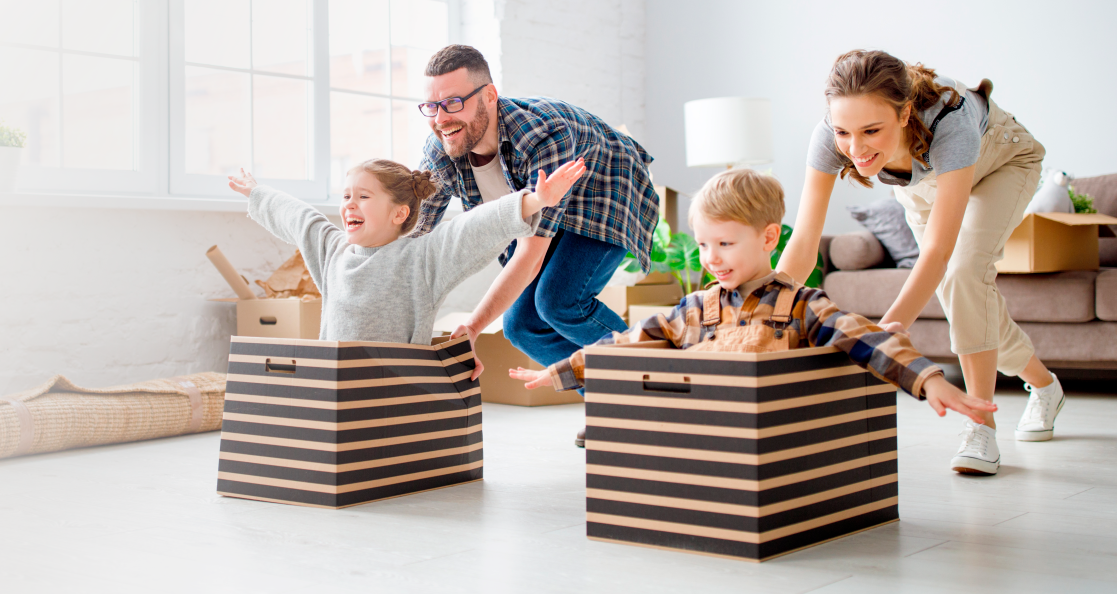 seguros de vida mujer, hombre, niña y niño pequeños, jugando con unas cajas