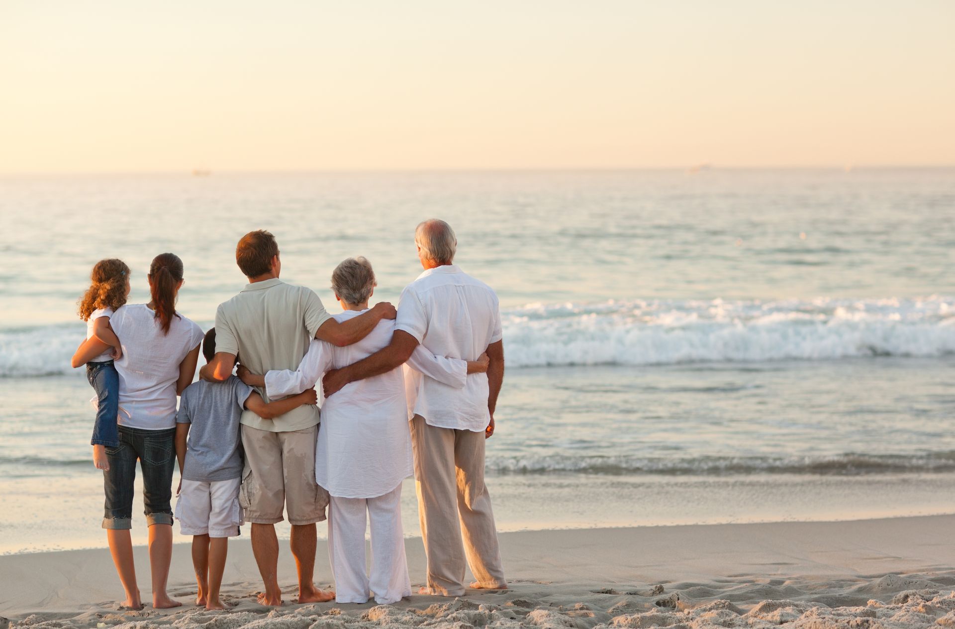 foto de una familia mirando al mar en una playa