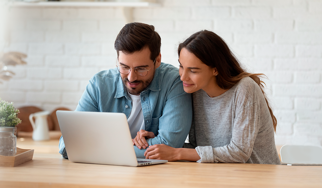 imagen pareja de hombre y mujer mirando un ordenador portátil