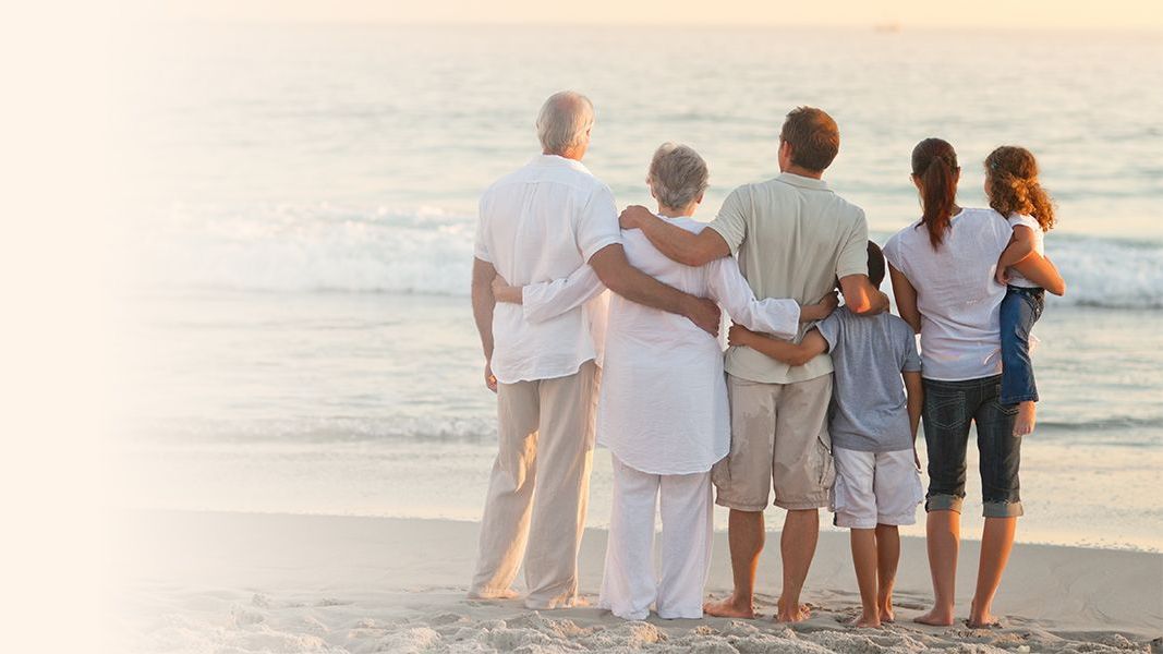 seguros de decesos una familia de seis personas contemplan un atardecer en la playa