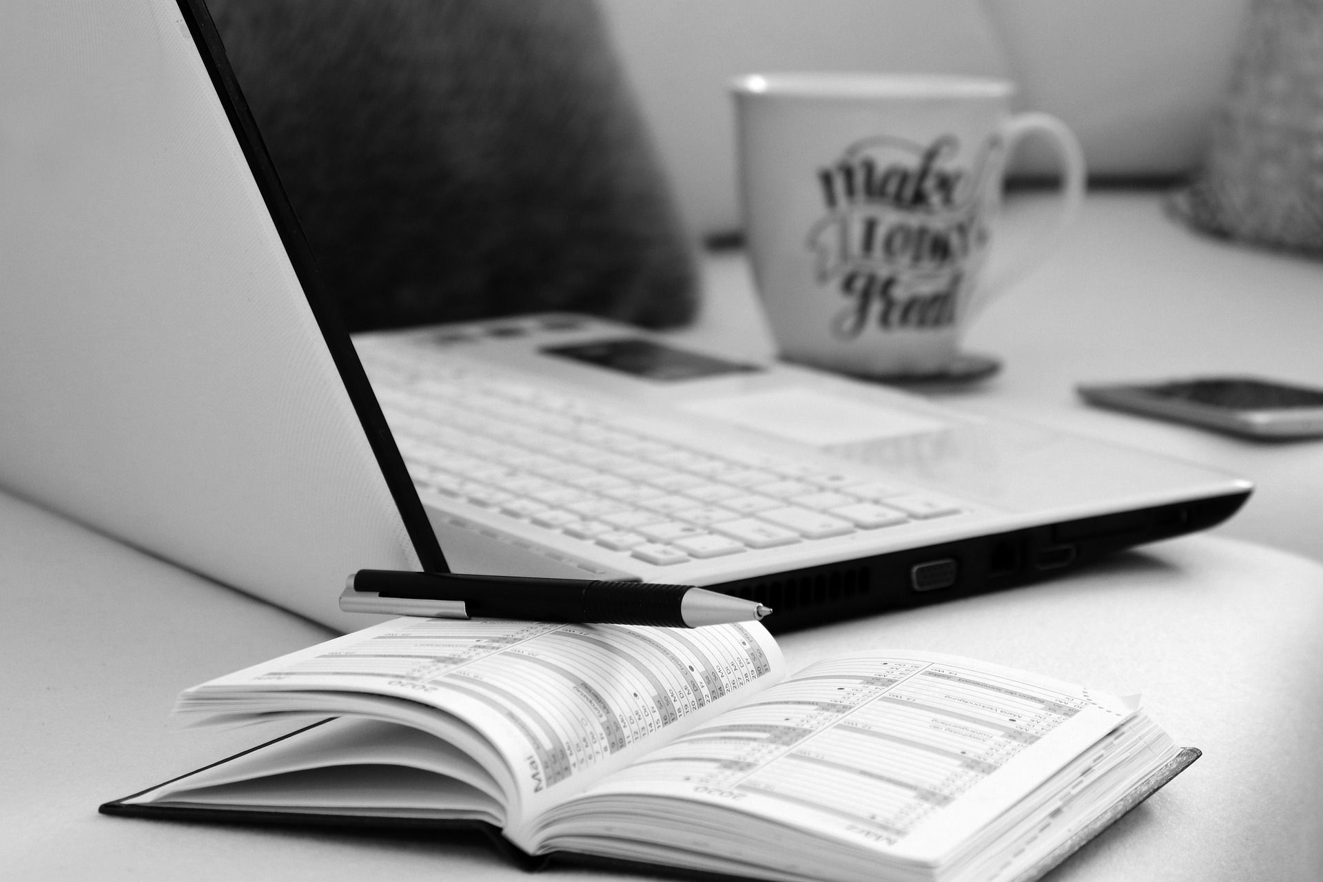 Laptop mit Tasse und Terminkalender