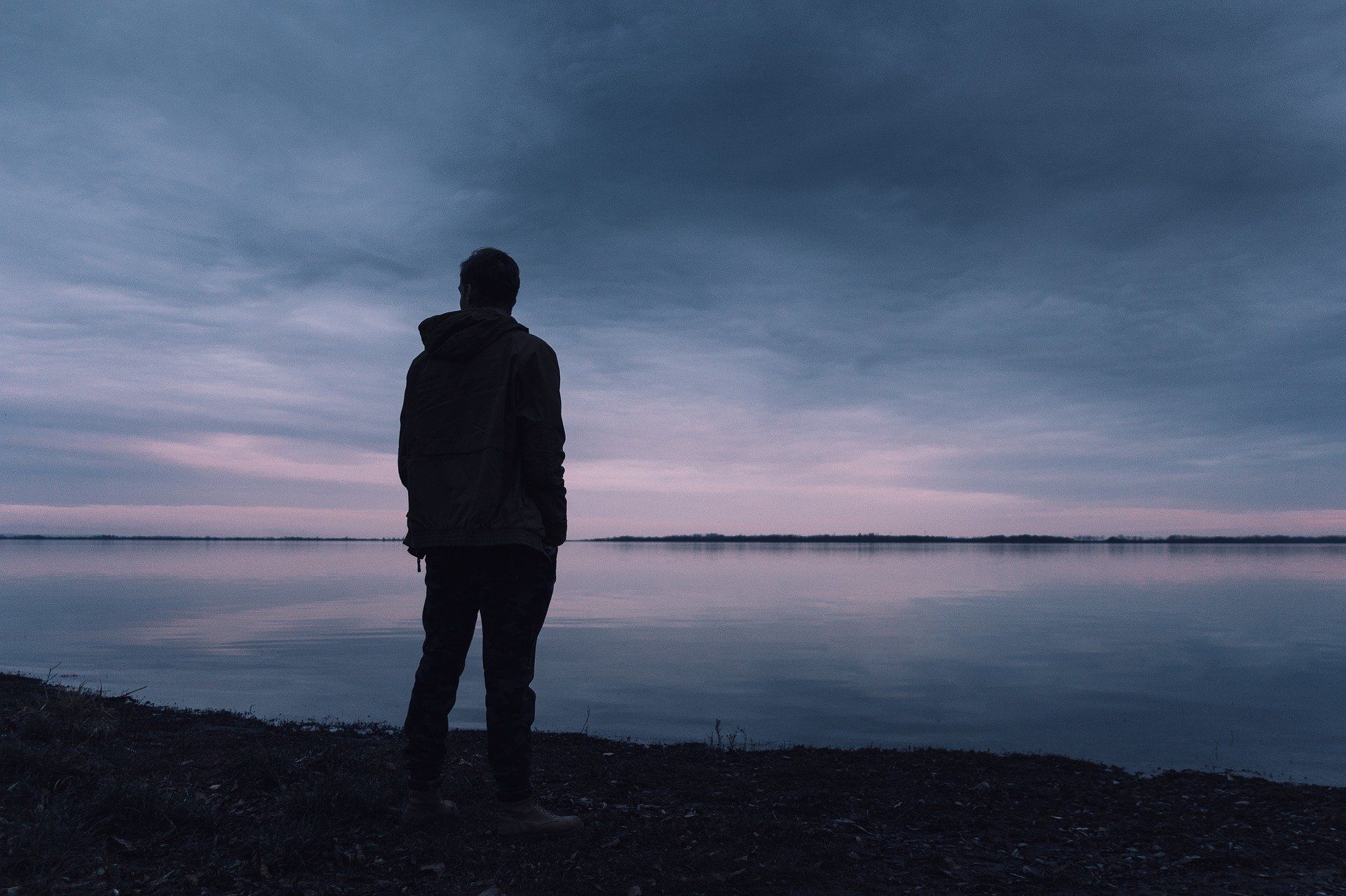 Silhouette eines Mannes am Ufer mit Blick in die Ferne