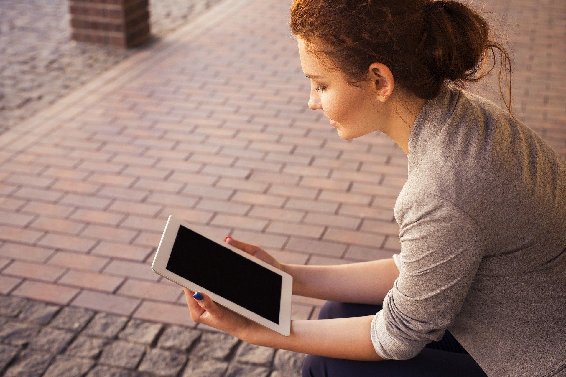 junge Frau beim Lesen am Tablet