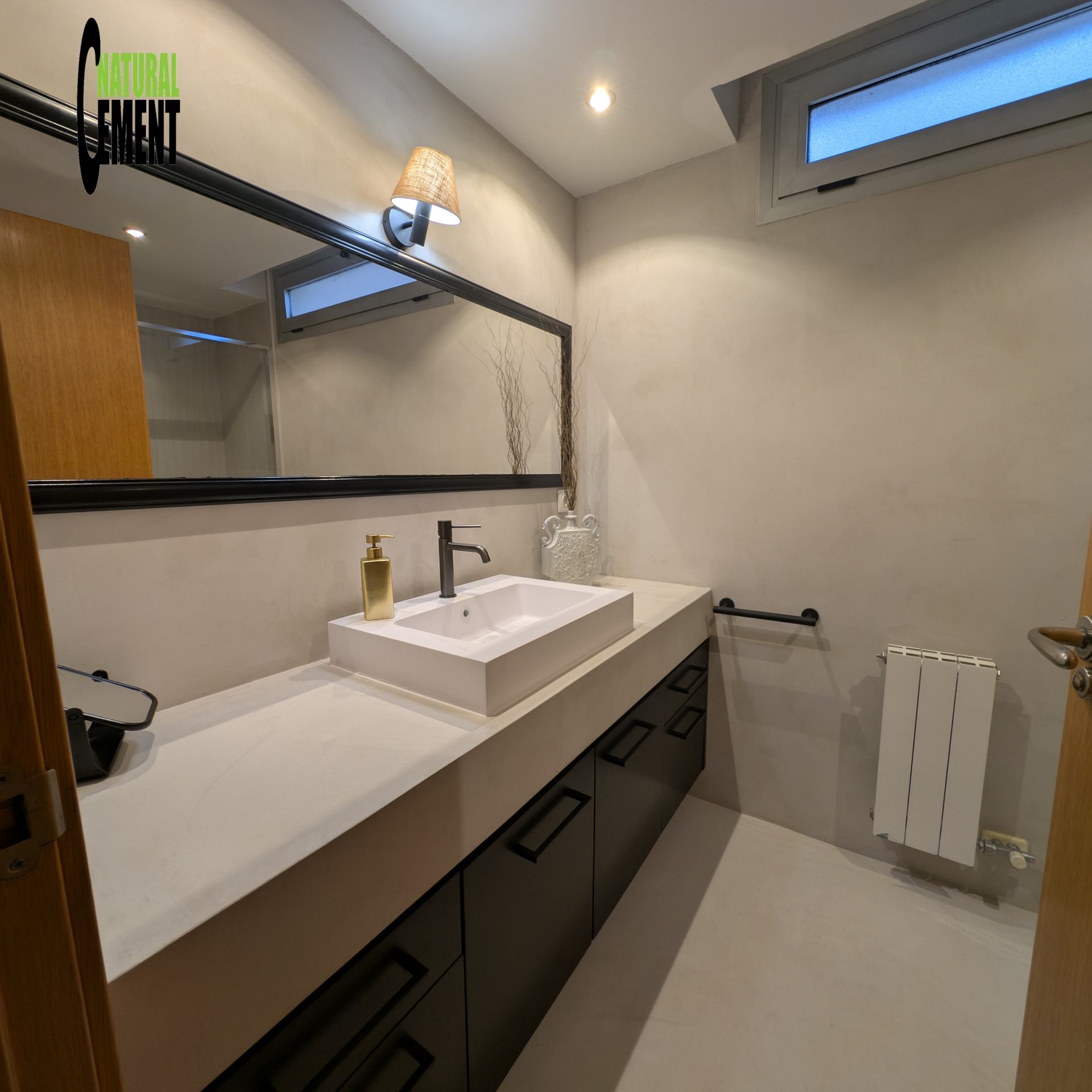 Baño completo con microcemento desde el suelo hasta el techo, ofreciendo continuidad visual.