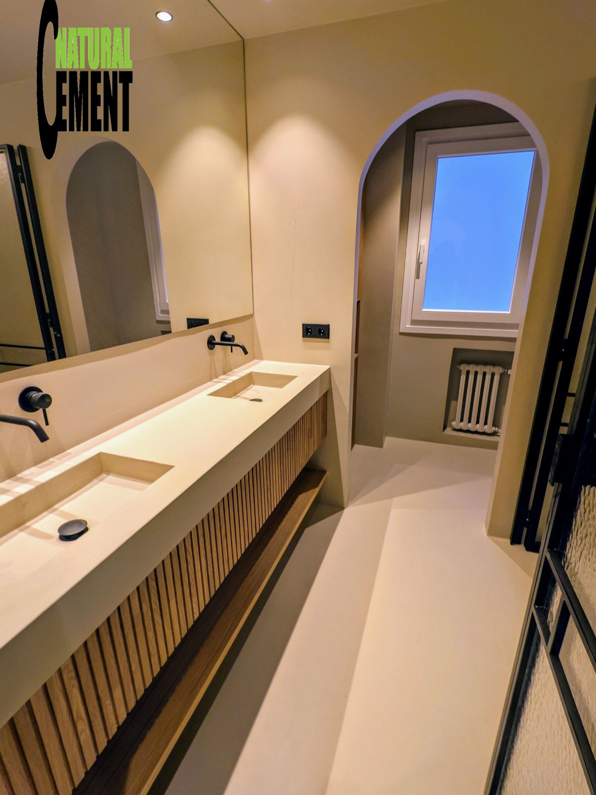 Detalle de logo de Natural Cement sobre textura de microcemento.