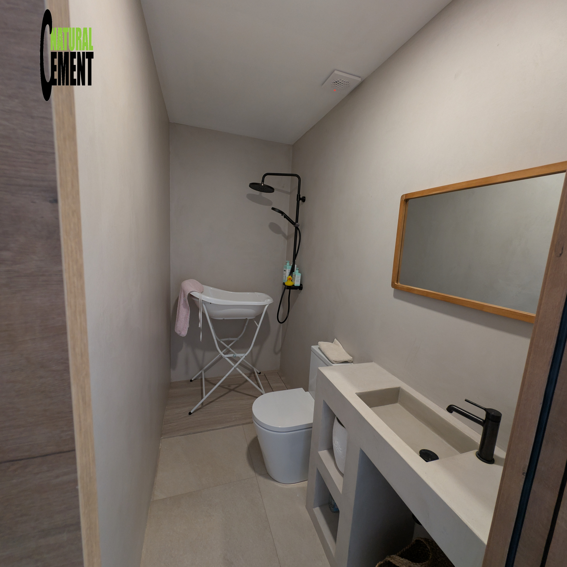 Baño completo reformado con microcemento color arena, incluyendo plato de ducha.