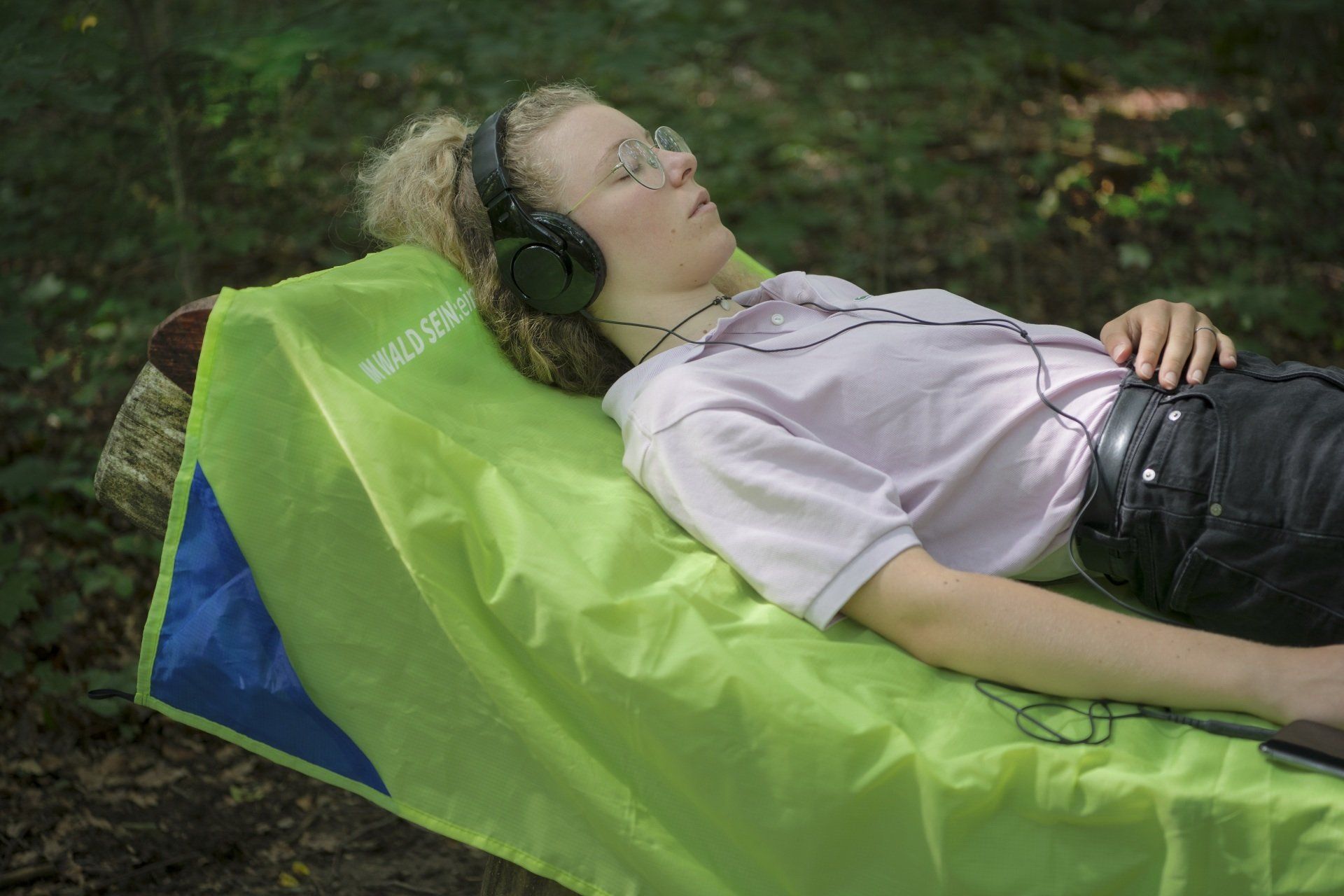 IM-WALD-SEIN: mit dem DIY-Shinrin-Yoku-Programm kann man gut entschleunigen Im-Wald-Sein: Frau entspannt auf Liege im Wald