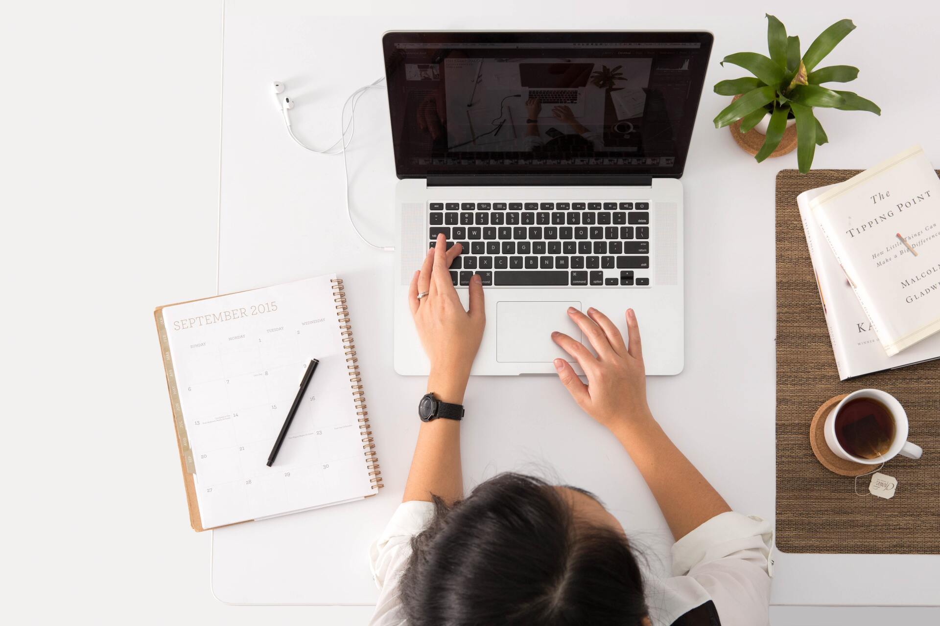 Une femme fait des recherches sur le status SAS/SASU sur son ordinateur portable à son bureau.