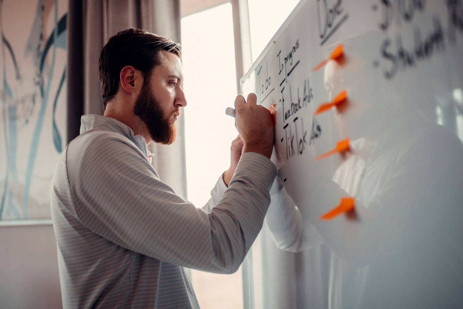 Personne écrivant sur un tableau son projet de création d'entreprise.