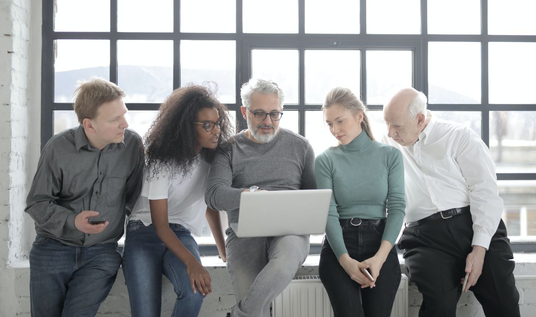 Leader inspirant guidant son équipe vers le succès en regardant un ordinateur portable ensemble.
