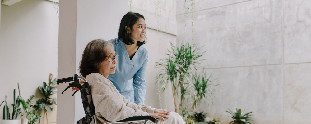 Infirmière assistant une femme âgée en fauteuil roulant dans un cadre de jardin paisible